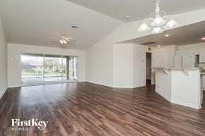 Cape Coral house for rent - an empty living room with a kitchen and a sliding glass door