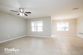 Cape Coral house for rent - A spacious room with a ceiling fan and two windows.