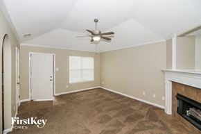 Cordova house for rent - a living room with a ceiling fan and a fireplace