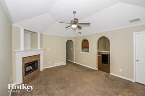 Cordova house for rent - a living room with a fireplace and a ceiling fan