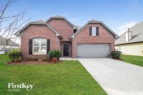 Calera house for rent - A brick house with a garage door and a driveway.