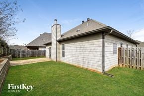 Calera house for rent - A house with a fence and a grassy yard.
