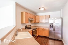 Noblesville house for rent - a kitchen with wooden cabinets and a stainless steel refrigerator