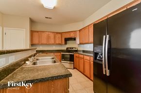 Cordova house for rent - a kitchen with wooden cabinets and stainless steel appliances and granite counter tops