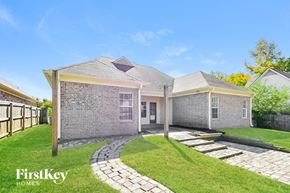 Cordova house for rent - a brick house with a grassy yard and a pathway to the front door