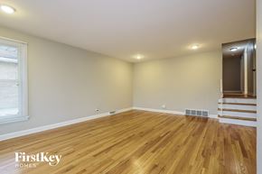 South Holland house for rent - the living room of an empty house with wooden floors and stairs