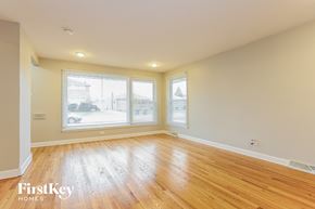 South Holland house for rent - an empty living room with wood floors and large windows