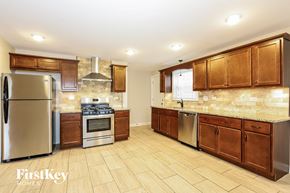 South Holland house for rent - a kitchen with wooden cabinets and stainless steel appliances