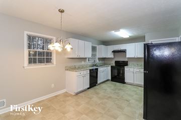 Woodstock house for rent - A kitchen with black appliances and white cabinets.