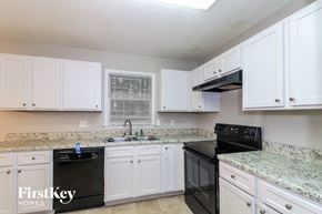 Woodstock house for rent - A kitchen with black appliances and white cabinets.