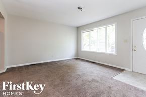 Indianapolis house for rent - a bedroom with a carpeted floor and a large window