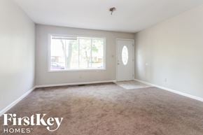 Indianapolis house for rent - an empty living room with a large window and carpet