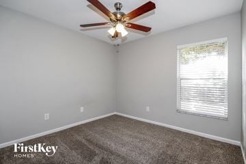 Riverview house for rent - the living room of a home with a ceiling fan and carpet