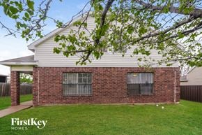 Dallas house for rent - front view of a white house with a yard and a tree