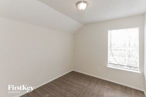 Dallas house for rent - a bedroom with white walls and a window and a brown carpet