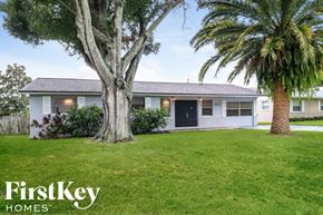 Largo house for rent - a white house with a lawn and palm trees