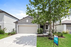 Riverview house for rent - A house with a garage and a tree in front of it.