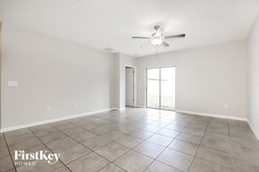 Riverview house for rent - A spacious room with a ceiling fan and sliding glass doors.