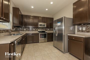 Indian Trail house for rent - A kitchen with brown cabinets and a stainless steel refrigerator.