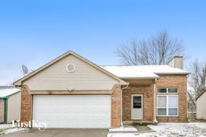 Indianapolis house for rent - A house with a garage door and a brick wall.