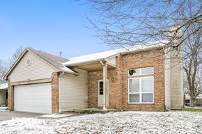 Indianapolis house for rent - A house with a garage and a driveway covered in snow.