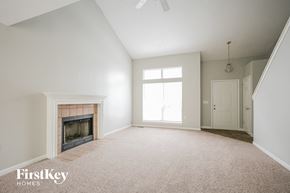 Indianapolis house for rent - A spacious room with a fireplace and a carpeted floor.