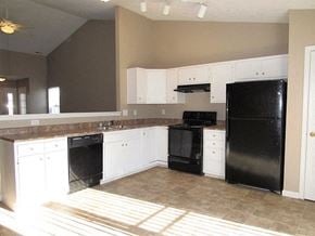 Indianapolis house for rent - a kitchen with black appliances and white cabinets