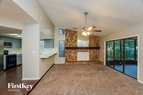 Plant City house for rent - an empty living room with a kitchen and a ceiling fan