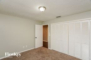 Plant City house for rent - a bedroom with white closet doors and a door to a hallway