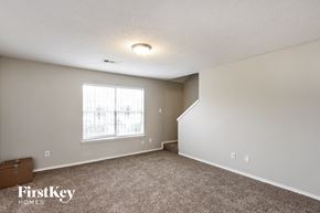 Dallas house for rent - a spacious living room with carpet and a window