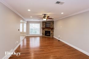 Cordova house for rent - a living room with a fireplace and a ceiling fan