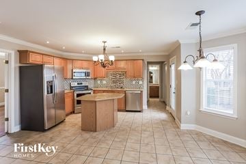 Cordova house for rent - a kitchen with wooden cabinets and stainless steel appliances