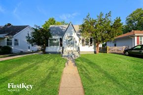 Waukegan house for rent - A house with a white picket fence and a car parked in front.