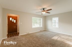 Waukegan house for rent - A carpeted room with a ceiling fan and two windows.