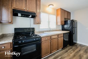 Waukegan house for rent - A kitchen with wooden cabinets and a black stove top oven.