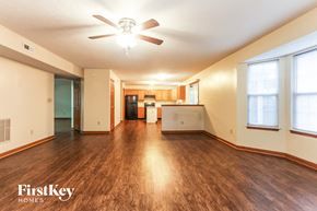 Bargersville house for rent - an empty living room with a ceiling fan and a kitchen