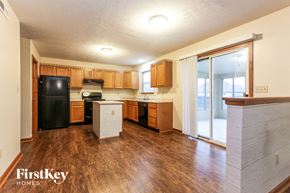 Bargersville house for rent - an empty kitchen with wood flooring and a black refrigerator