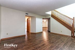 Bargersville house for rent - the living room and entryway of an empty house with white walls and wood floors