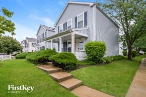 Aurora house for rent - a white house with stairs in front of a lawn