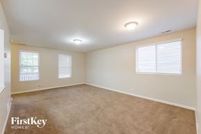 Aurora house for rent - a bedroom with a carpeted floor and two windows