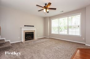 Charlotte house for rent - A living room with a fireplace and a ceiling fan.