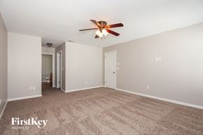 Charlotte house for rent - A spacious room with a carpeted floor and a ceiling fan.