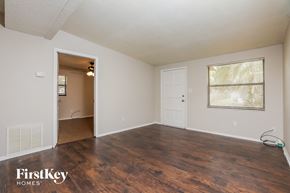 Winter Garden house for rent - an empty living room with wood flooring and a door to the kitchen