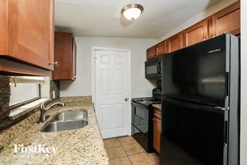 Winter Garden house for rent - a kitchen with black appliances and granite counter tops