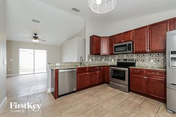 Poinciana house for rent - a kitchen with wooden cabinets and stainless steel appliances