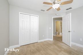Poinciana house for rent - a bedroom with a ceiling fan and a door to a bathroom
