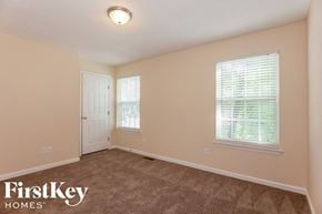 Charlotte house for rent - a bedroom with a carpeted floor and a white door