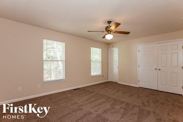 Charlotte house for rent - a living room with carpet and a ceiling fan