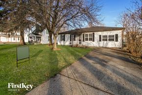 Greenfield house for rent - a white house with a lawn and trees in front of it