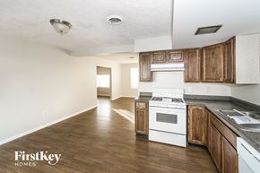 Greenfield house for rent - an empty kitchen with wooden cabinets and a white stove